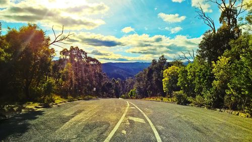 Road amidst trees against sky