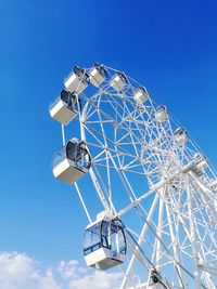 Low angle view of ferris wheel against blue sky