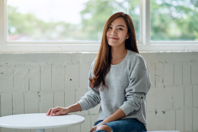 Portrait of young woman sitting at home