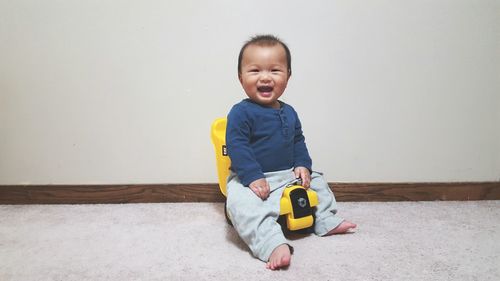 Portrait of happy baby boy with toy at home