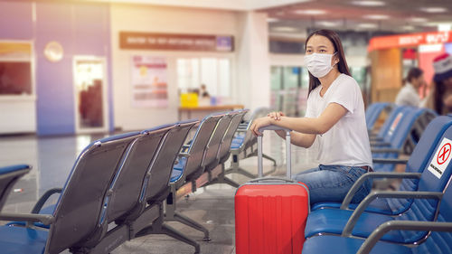 Woman sitting on seat at airport