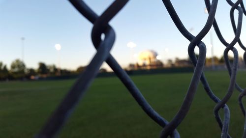 Close-up of chainlink fence on field