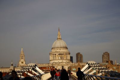 Tourists outside building against sky in city