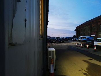 Cars on road by buildings against sky