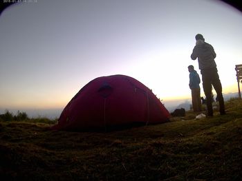 Tent on field against sky during sunset