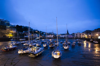 Boats moored in harbor at night