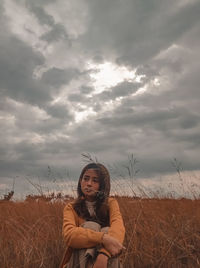 Portrait of young woman on field against sky