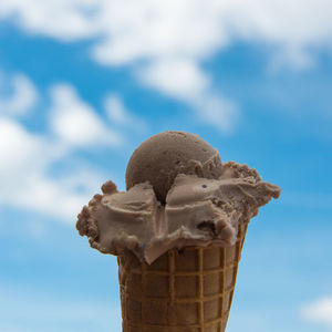 Close-up of ice cream cone against sky