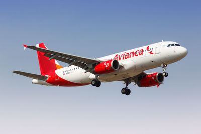 Low angle view of red airplane against clear sky