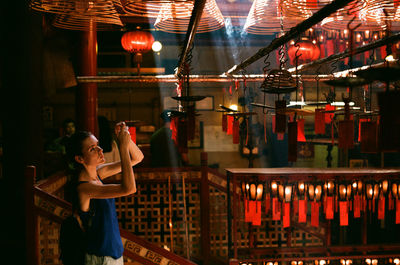 Low angle view of illuminated woman in dark room