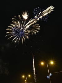Low angle view of firework display at night