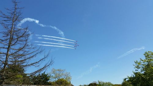 Low angle view of airplane flying against blue sky