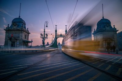 Blurred motion of vehicles moving on bridge in city during sunset