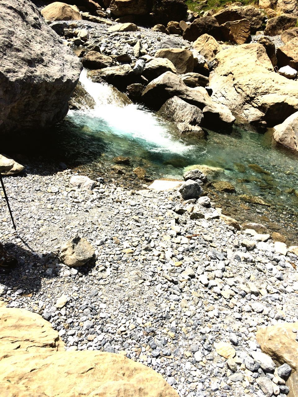 water, rock - object, tranquility, nature, high angle view, stone - object, sunlight, tranquil scene, beauty in nature, rock formation, beach, stone, day, shore, scenics, outdoors, rock, reflection, textured, shadow