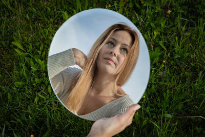 Portrait of young woman wearing hat on field