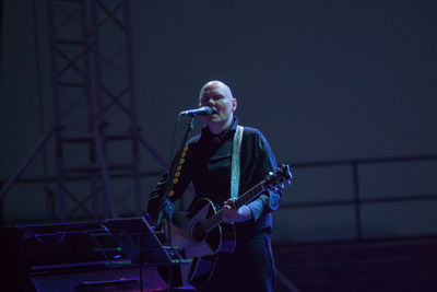 Man playing guitar at music concert