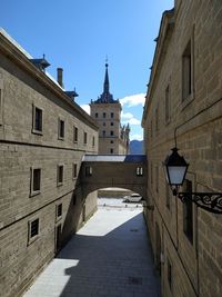 Alley amidst buildings in city against sky