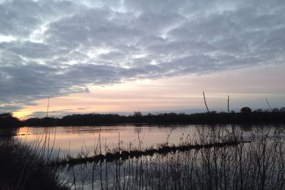 Scenic view of lake against cloudy sky