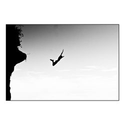 Low angle view of silhouette bird flying in sky