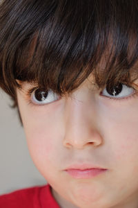 Close-up of young cute boy with eyes wide open and looking away from camera.