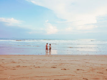 Happy romantic couple enjoying beautiful sunset walk on the beach. pastel colors tone