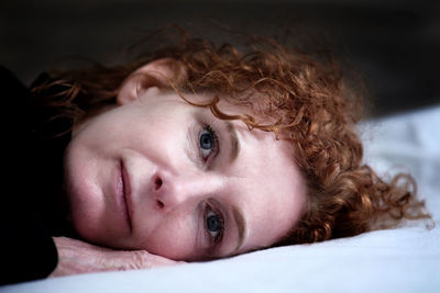 Close-up portrait of girl lying on bed