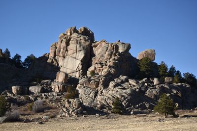Rock formations on landscape against clear blue sky