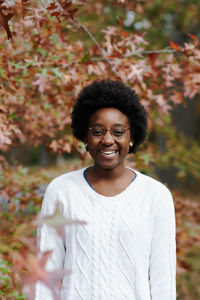 Portrait of smiling woman standing outdoors during autumn