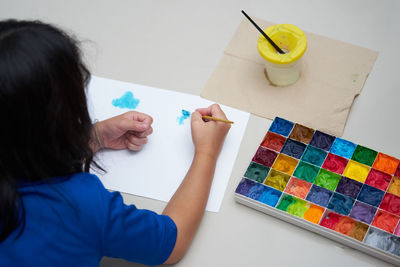 High angle view of girl drawing on table