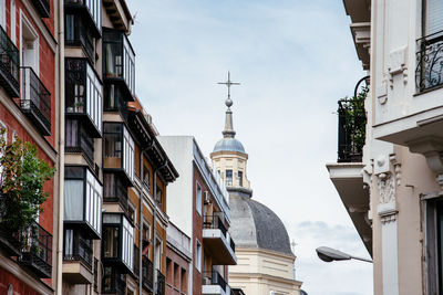 Low angle view of church and buildings in city against sky