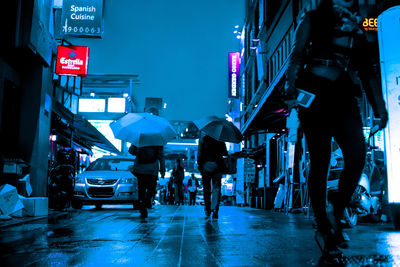 People walking on illuminated city