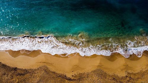 High angle view of waves splashing on beach