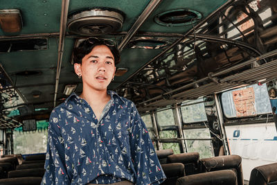 Young man standing in abandoned bus