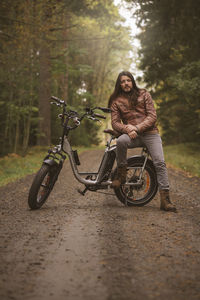 Man riding motor scooter on road