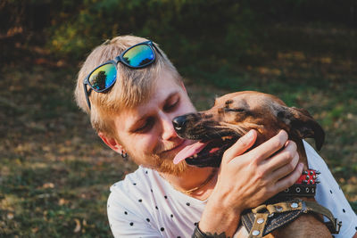 Close-up of a man with dog on field