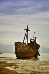 Old ship wrecked on the greek coast and abandoned on the beach. concept of abandoned and failure