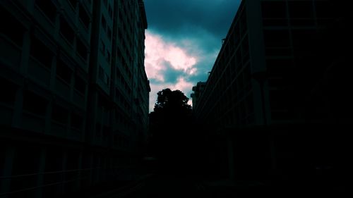 Low angle view of silhouette buildings against sky