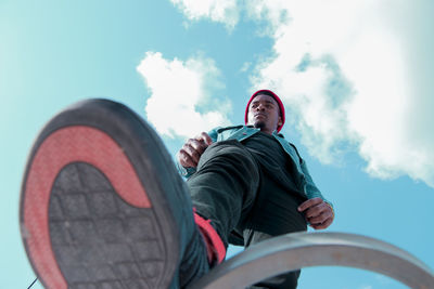 Low angle view of man sitting against sky