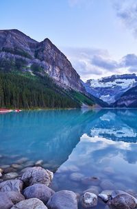 Scenic view of lake by mountains against sky