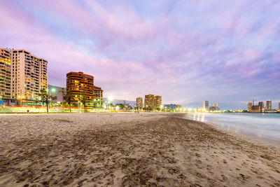 Surface level of beach against sky in city