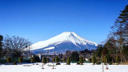 Scenic view of snowcapped mountains against clear blue sky