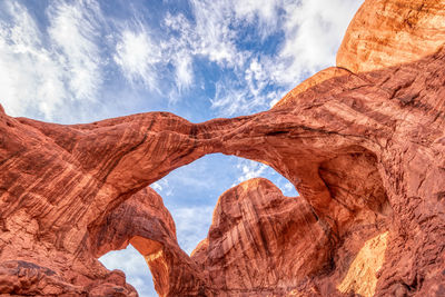 Low angle view of rock formation against sky at arches national park.