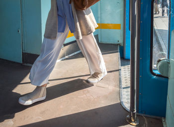 Low section of woman walking in bus