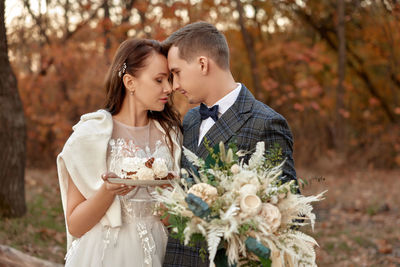 Portrait of smiling couple holding bouquet