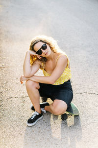 Portrait of woman wearing sunglasses sitting outdoors