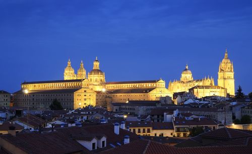 View of buildings in city against blue sky