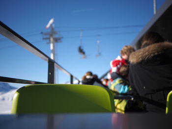 Rear view of women sitting against clear sky