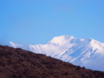 Scenic view of snowcapped mountains against blue sky