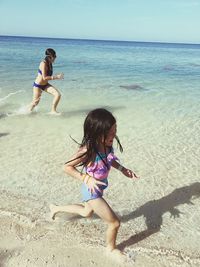 Siblings running at beach