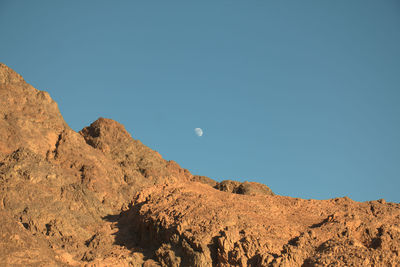 Low angle view of mountain against clear blue sky